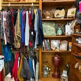 A Block City vendor booth with clothing racks and shelves of home decor.